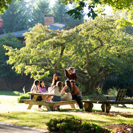 Students sitting at a picnic table.