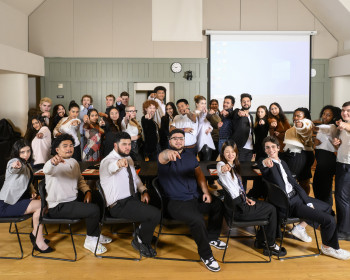 Large group of students all pointing at the camera.