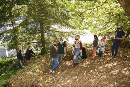 Students clearing brush with the Center for Social Change and Community Involvement as part of a ...