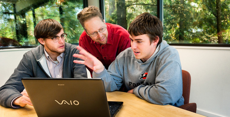 Julian Dale '12 (L) and Nic Wilson '12 (R) talk with Professor of Computer Science Jens Mache