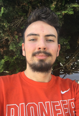 Ben, standing in front of trees, smiling in an L&C orange Nike shirt. Student-supplied profile photo due to COVID-19. Thank you, Ben!