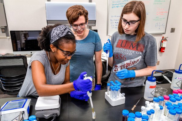 Professor Anne Bentley works with students in the chemistry lab.