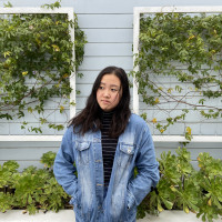 Alys, looking upward, standing in front of a vine-covered wall. Student-supplied profile photo due to COVID-19. Thank you, Alys!