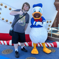 Terin giving a thumbs up while standing next to a person in a Donald Duck costume.