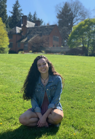 Juliana, smiling, sitting on the grass in front of the Manor House on a sunny day. Student-supplied profile photo due to COVID-19. Thank ...