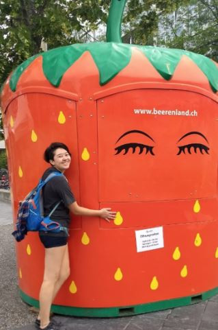 Erika hugging a large strawberry cart