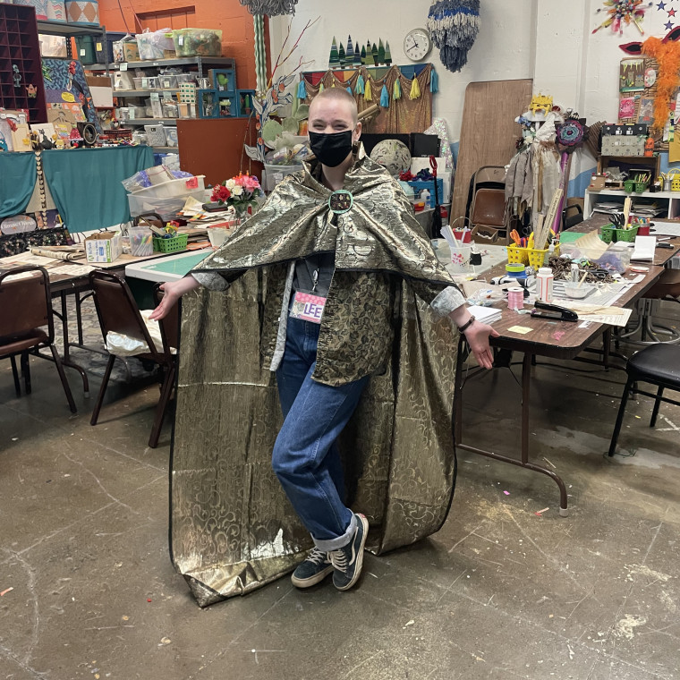 Lee Hinkle BA '24 interning at SCRAP, wearing a handmade, upcycled wizard's cape.