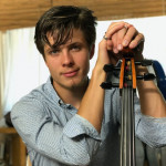 Orin posing and holding a cello.