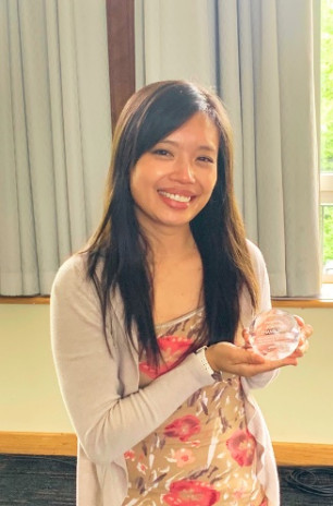 Joann Zhang smiling and holding award.