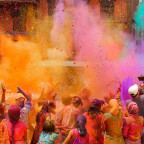 Colorful powder in the air thrown by people in a crowd.