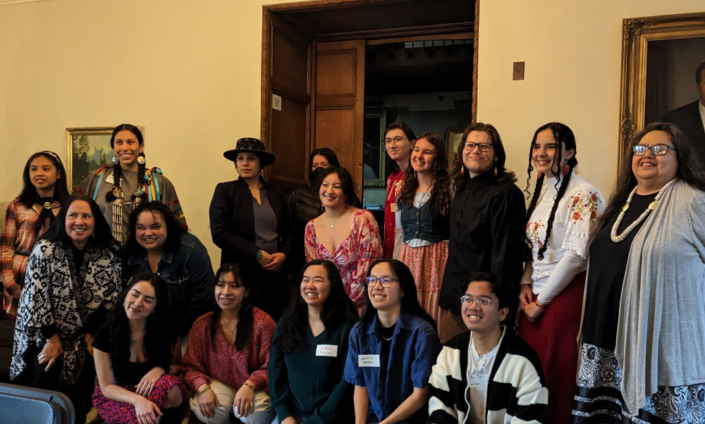 Twenty plus native graduates stand together for a photo