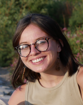 Headshot photo of Allison, wearing a tan tank top and glasses.