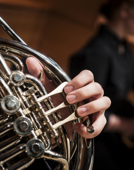 Close-up image of student playing wind instrument.