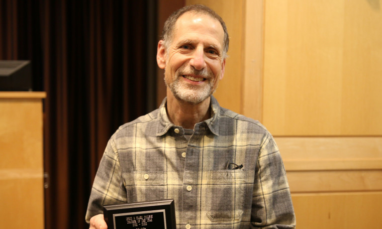 Associate Professor Michael Broide posing with his 2022 Teacher of the Year award.